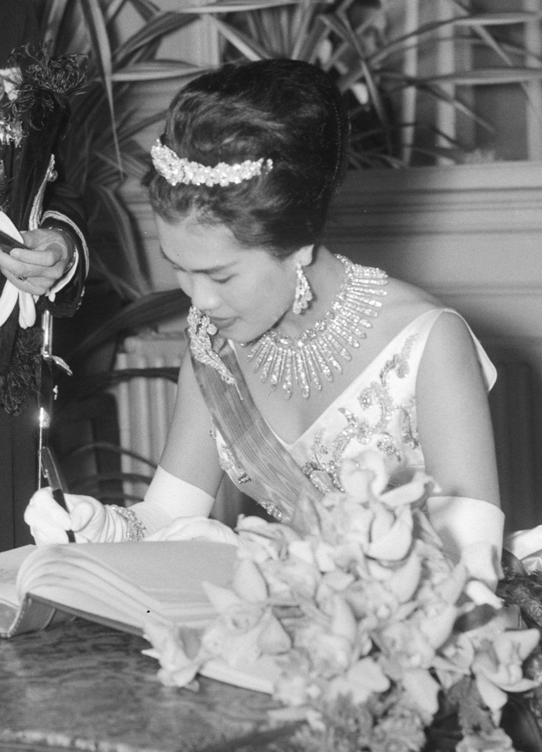 La regina Sirikit di Thailandia firma un libro degli ospiti prima di un concerto di gala all'Aia il 25 ottobre 1960 (Joop van Bilsen/Anefo/Nationaal Archief/Wikimedia Commons)