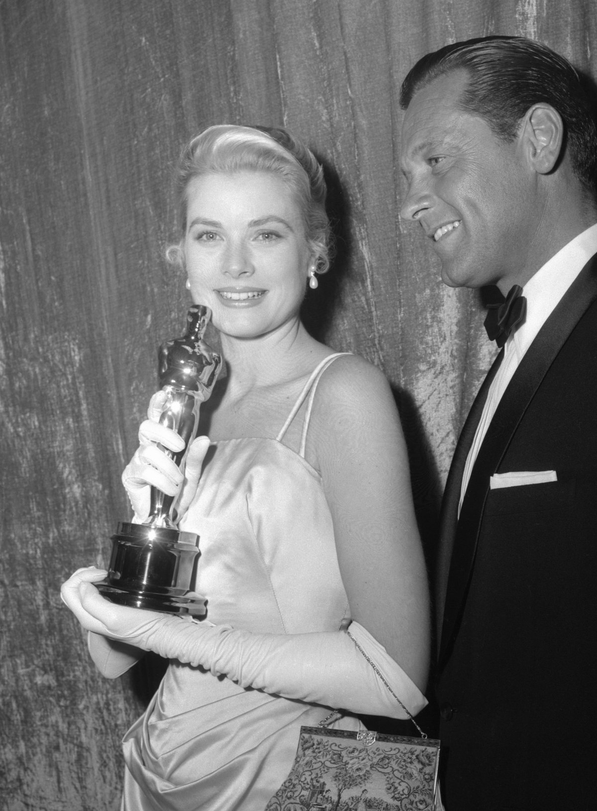 Grace Kelly, mentre tiene il suo Oscar come Migliore Attrice, posa dietro le quinte con William Holden dopo la 27ª Annual Academy Awards al Pantages Theatre di Hollywood il 30 marzo 1955 (Los Angeles Times Photographic Collection/UCLA Library)