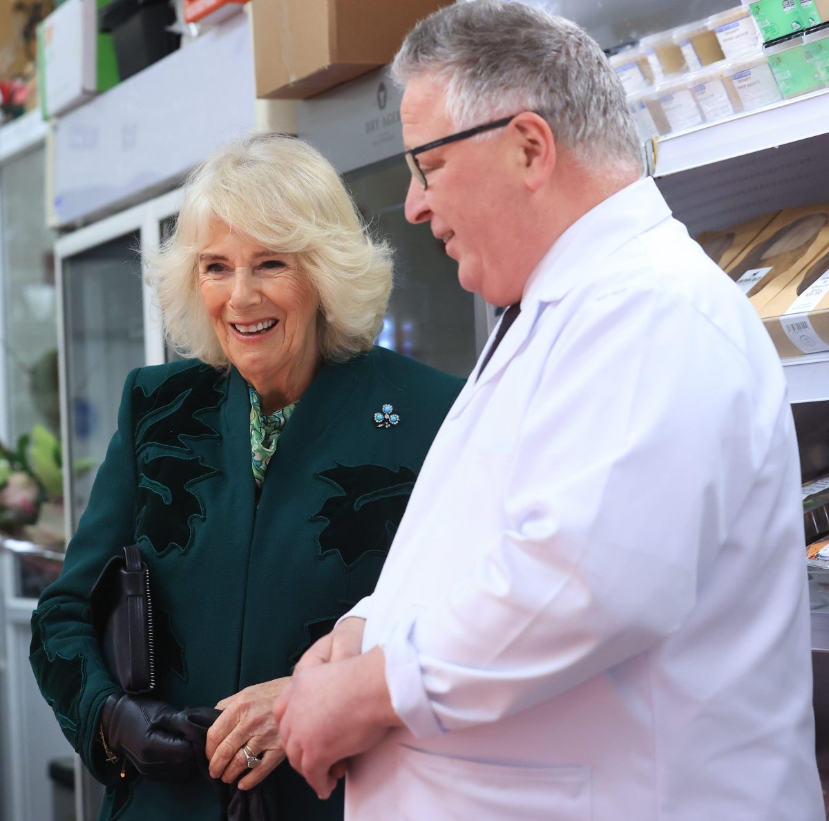 Queen Camilla of the United Kingdom meets the owner of Coffey's Butchers during a visit to Lisburn Road in Belfast on March 21, 2024 (Liam McBurney/PA Images/Alamy)