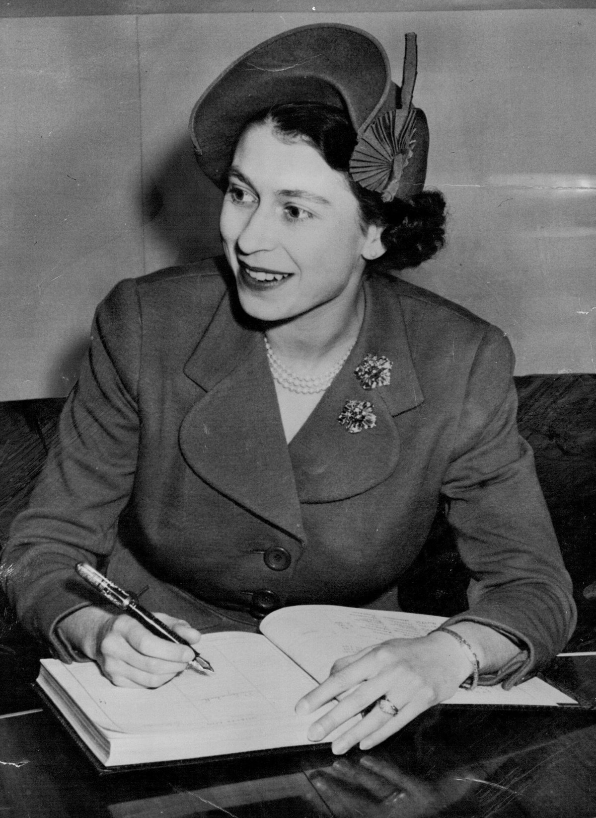 La Principessa Elisabetta del Regno Unito firma il libro degli ospiti della Royal Canadian Air Force durante il volo da Montreal a Washington, ottobre 1951 (SuperStock/Alamy)