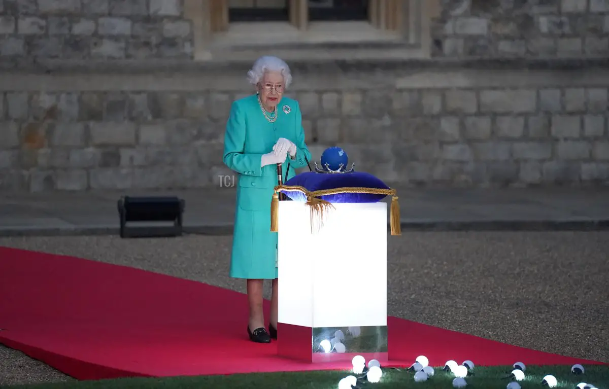 La regina Elisabetta II del Regno Unito si prepara a toccare il Globo delle Nazioni del Commonwealth per avviare l'accensione del Faro Principale davanti al Palazzo di Buckingham a Londra, dal Cortile del Castello di Windsor, a ovest di Londra, come parte delle celebrazioni del Giubileo di Platino il 2 giugno 2022 a Windsor, Inghilterra