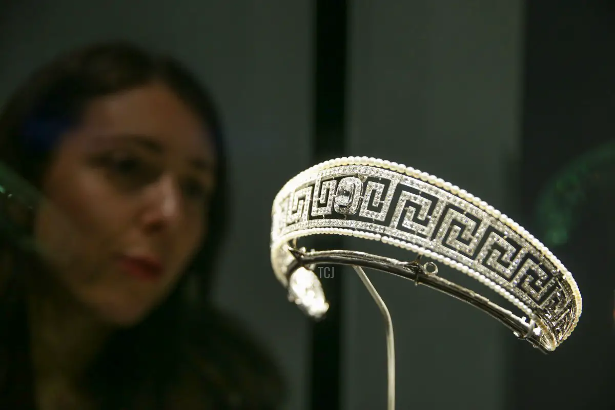 Un dipendente del museo posa accanto a una tiara Cartier di diamanti e perle salvata dal Lusitania presentata in una nuova mostra 'Ocean Liners: Speed and Style' al Victoria and Albert Museum di Londra il 31 gennaio 2018