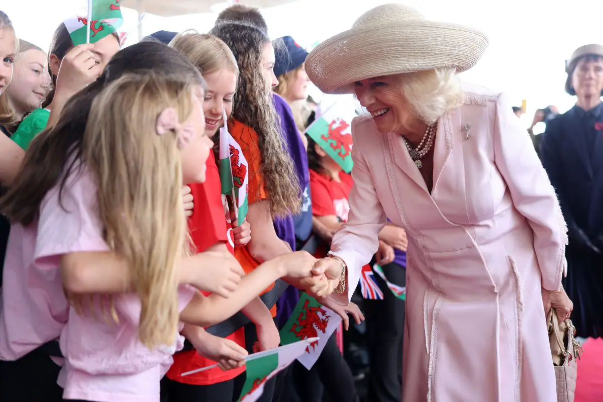 La Regina Camilla incontra i bambini all'esterno del Senedd a Cardiff durante le celebrazioni per il 25° anniversario