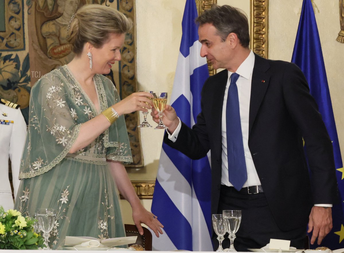 La regina Mathilde del Belgio e Pavolos Kotsonis, partner dell'HE Presidente Sakellaropoulou, brindano con un bicchiere di vino durante una cena di stato con il presidente Sakellaropoulou il primo giorno di una visita di stato di tre giorni della coppia reale belga in Grecia, lunedì 02 maggio 2022, ad Atene