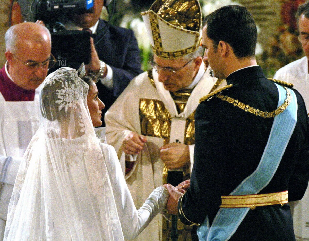 Il Principe di Borbone Felipe di Spagna mette l'anello sul dito della sua sposa Letizia Ortiz davanti all'Arcivescovo di Madrid Antonio Maria Rouco Varela (C) durante la cerimonia di matrimonio nella Cattedrale dell'Almudena a Madrid il 22 maggio 2004