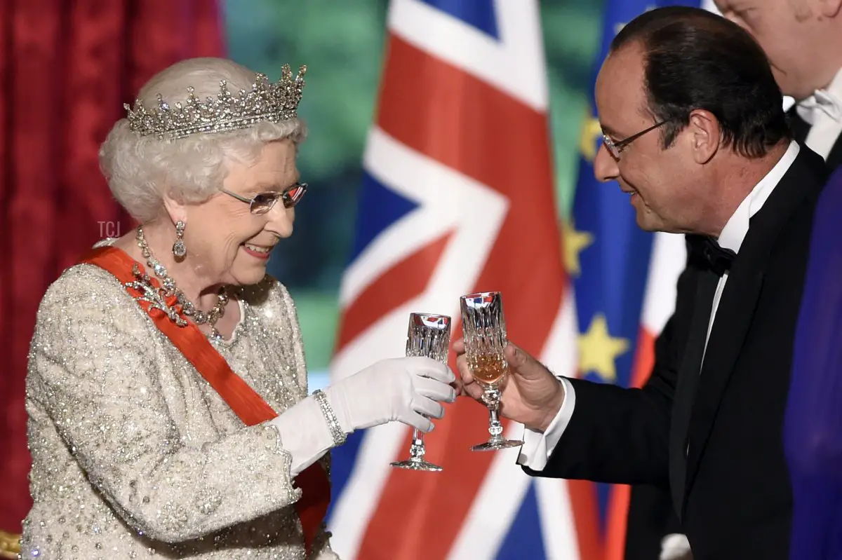 La regina britannica Elisabetta II brinda con il presidente francese François Hollande durante una cena di stato al Palazzo dell'Élysée a Parigi, dopo le cerimonie di commemorazione del D-Day in Normandia, che segna il settantesimo anniversario degli sbarchi alleati della seconda guerra mondiale in Normandia, 6 giugno 2014 (ERIC FEFERBERG/AFP via Getty Images)