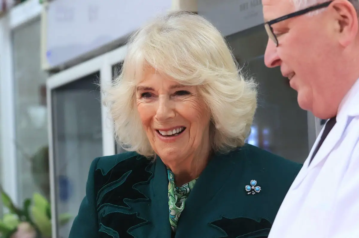 Queen Camilla of the United Kingdom meets the owner of Coffey's Butchers during a visit to Lisburn Road in Belfast on March 21, 2024 (Liam McBurney/PA Images/Alamy)